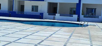 a swimming pool in front of a building at Oasis marina in Hurghada