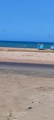 a beach with two boats in the water and a boat at Oasis marina in Hurghada