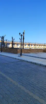 a cobblestone street with palm trees on the beach at Oasis marina in Hurghada