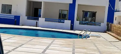 a large swimming pool with blue and white walls at Oasis marina in Hurghada