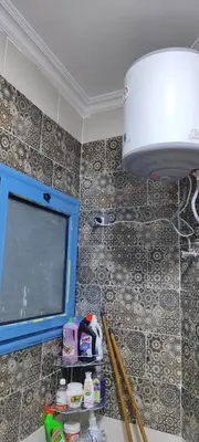 a bathroom with a tv and a tiled wall at Oasis marina in Hurghada
