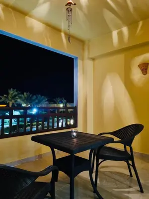 a table and two chairs in a room with a television at Apartment in Port Ghalib Marina City in Port Ghalib