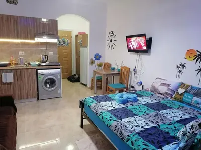 a bedroom with a bed and a kitchen with a table at Studio Sheraton Plaza in Hurghada