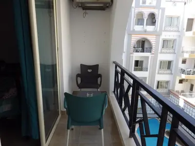 a cat sitting on a chair on a balcony at Studio Sheraton Plaza in Hurghada