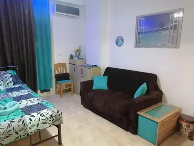 a living room with a couch and a chair at Studio Sheraton Plaza in Hurghada