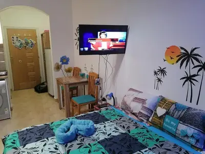 a bedroom with a bed and a tv on the wall at Studio Sheraton Plaza in Hurghada