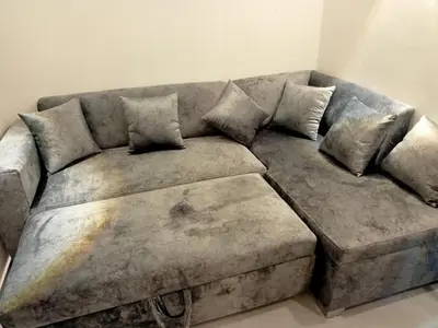 a gray couch with pillows on it in a living room at Seafront Hotel Apartment with private beach in Hurghada