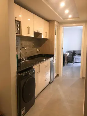 a kitchen with a sink and a dishwasher at Seafront Hotel Apartment with private beach in Hurghada