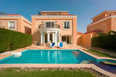 a house with a swimming pool in the yard at Arena Beach Resort - Premium Suites in Hurghada