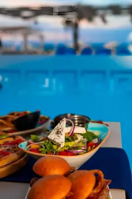 a table with two plates of food and a bowl of salad at Arena Beach Resort - Premium Suites in Hurghada
