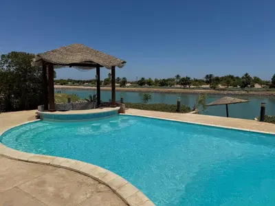 a swimming pool with a gazebo next to a lake at NEXT STAY, 3BR Villa, El Gouna in Hurghada