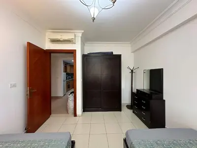 a bedroom with two beds and a dresser and a television at Panoramic Sea View in Hurghada