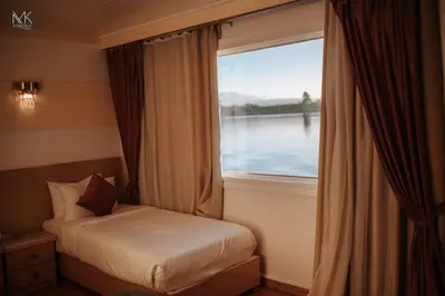 a bedroom with a bed and a large window at FayedBasmadahabiya in Luxor