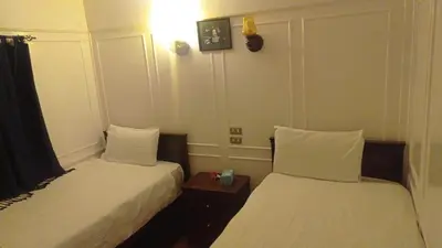 a room with two beds and a night stand withskirts at FayedBasmadahabiya in Luxor