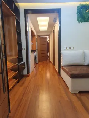 a living room with a bed and a wooden floor at luxury apartment with sea view in Hurghada