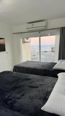 two beds in a bedroom with a view of the ocean at Маленький голубий кит in Hurghada