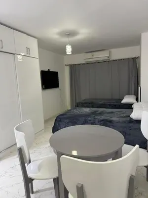 a room with a bed and a table and chairs at Маленький голубий кит in Hurghada