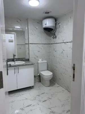 a white bathroom with a toilet and a sink at Маленький голубий кит in Hurghada
