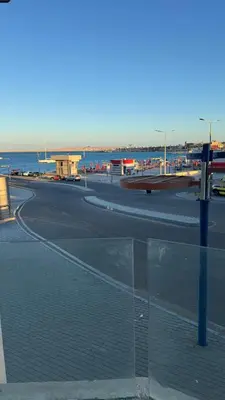 an empty street with the ocean in the background at Маленький голубий кит in Hurghada