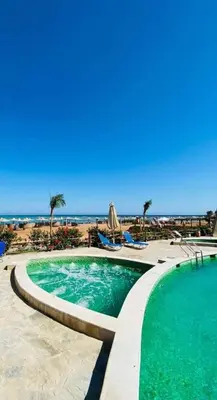 a swimming pool with the beach in the background at Studio in turtels beach in Hurghada