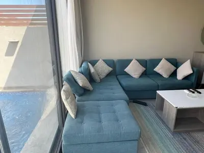 a blue couch in a living room with a window at One Bedroom Apartment in El Gouna Bali in Hurghada