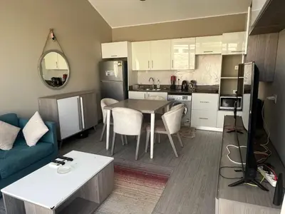 a kitchen and living room with a table and a couch at One Bedroom Apartment in El Gouna Bali in Hurghada