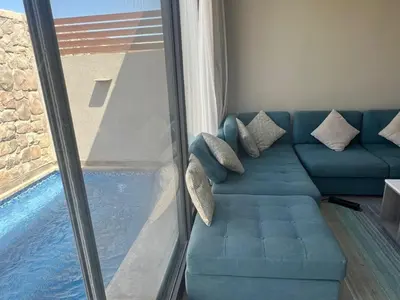 a living room with a blue couch next to a window at One Bedroom Apartment in El Gouna Bali in Hurghada