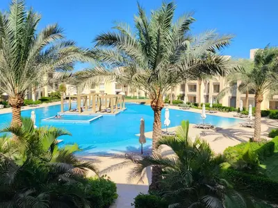 a swimming pool with palm trees in a resort at ELgouna Mangroovy stylish 4 bedroom in Hurghada