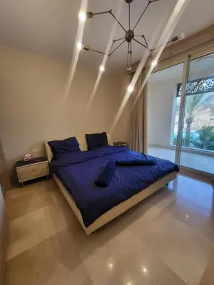 a bedroom with a bed with blue sheets and a chandelier at ELgouna Mangroovy stylish 4 bedroom in Hurghada