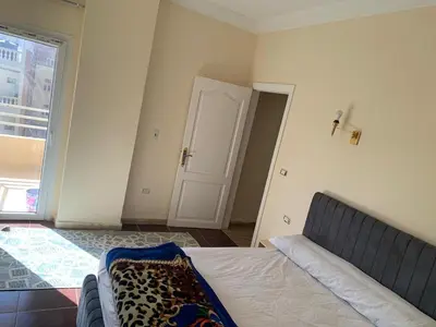 a bedroom with a bed and a window and a door at Downtown Studio in Hurghada