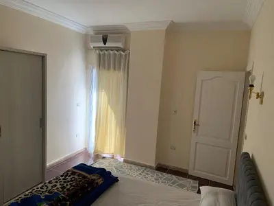 a bedroom with a bed and a door to a window at Downtown Studio in Hurghada