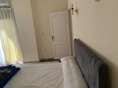a bedroom with a bed and a door to a window at Downtown Studio in Hurghada