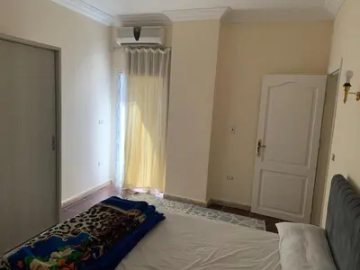 a bedroom with a bed and a window and a door at Downtown Studio in Hurghada
