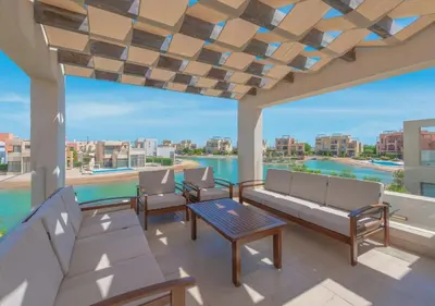 a patio with furniture and a view of the water at Beautiful 4BR Villa in Tawila El Gouna Private Pool & Lagoon Access in Hurghada