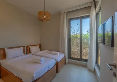 two beds in a room with a large window at Beautiful 4BR Villa in Tawila El Gouna Private Pool & Lagoon Access in Hurghada