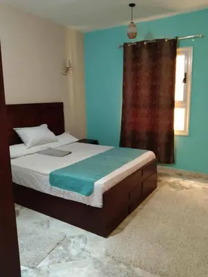 a bedroom with a bed with blue walls and a window at Magyipt in Hurghada