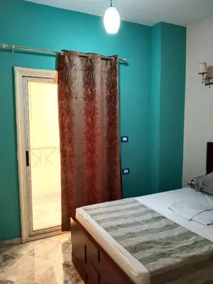 a bedroom with a bed and a window with a curtain at Magyipt in Hurghada