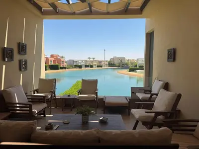a living room with a large view of a pool at NEXT STAY, Lagoon Townhouse, El Gouna in Hurghada
