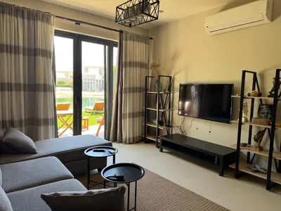 a living room with a couch and a tv at NEXT STAY, Lagoon Townhouse, El Gouna in Hurghada
