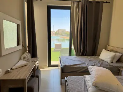 a bedroom with two beds and a large window at NEXT STAY, Lagoon Townhouse, El Gouna in Hurghada