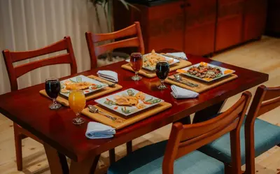 a wooden table with plates of food and glasses of wine at Azhar Dahabiya luxury suites in Esna
