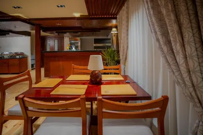 a dining room table with chairs and a lamp on it at Azhar Dahabiya luxury suites in Esna