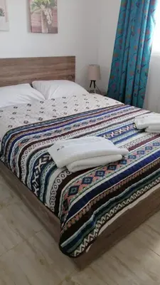 a bed with a colorful comforter and pillows on it at Flat in Hughada Aqua Palms 52 M2 in Hurghada