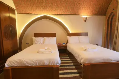two beds with towels on them in a room at Golden Land in ‘Ezbet Abu Ḥabashi
