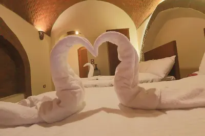 a bedroom with two swans shaped towels on a bed at Golden Land in ‘Ezbet Abu Ḥabashi