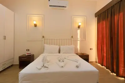 a bedroom with a white bed with towels on it at Golden Land in ‘Ezbet Abu Ḥabashi