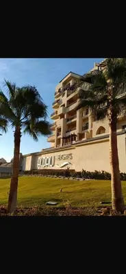 two palm trees in front of a large building at Hurghada in Hurghada