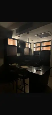 a dark room with a table and chairs and windows at Hurghada in Hurghada