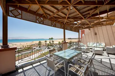 a patio with a table and chairs and a beach at VESTA - Soma Bay Residence in Hurghada