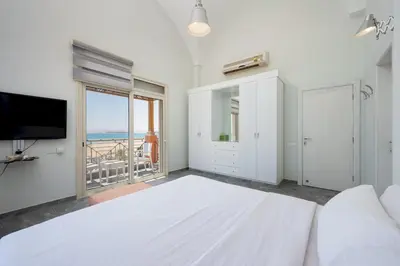 a white room with a large bed and a television at VESTA - Soma Bay Residence in Hurghada